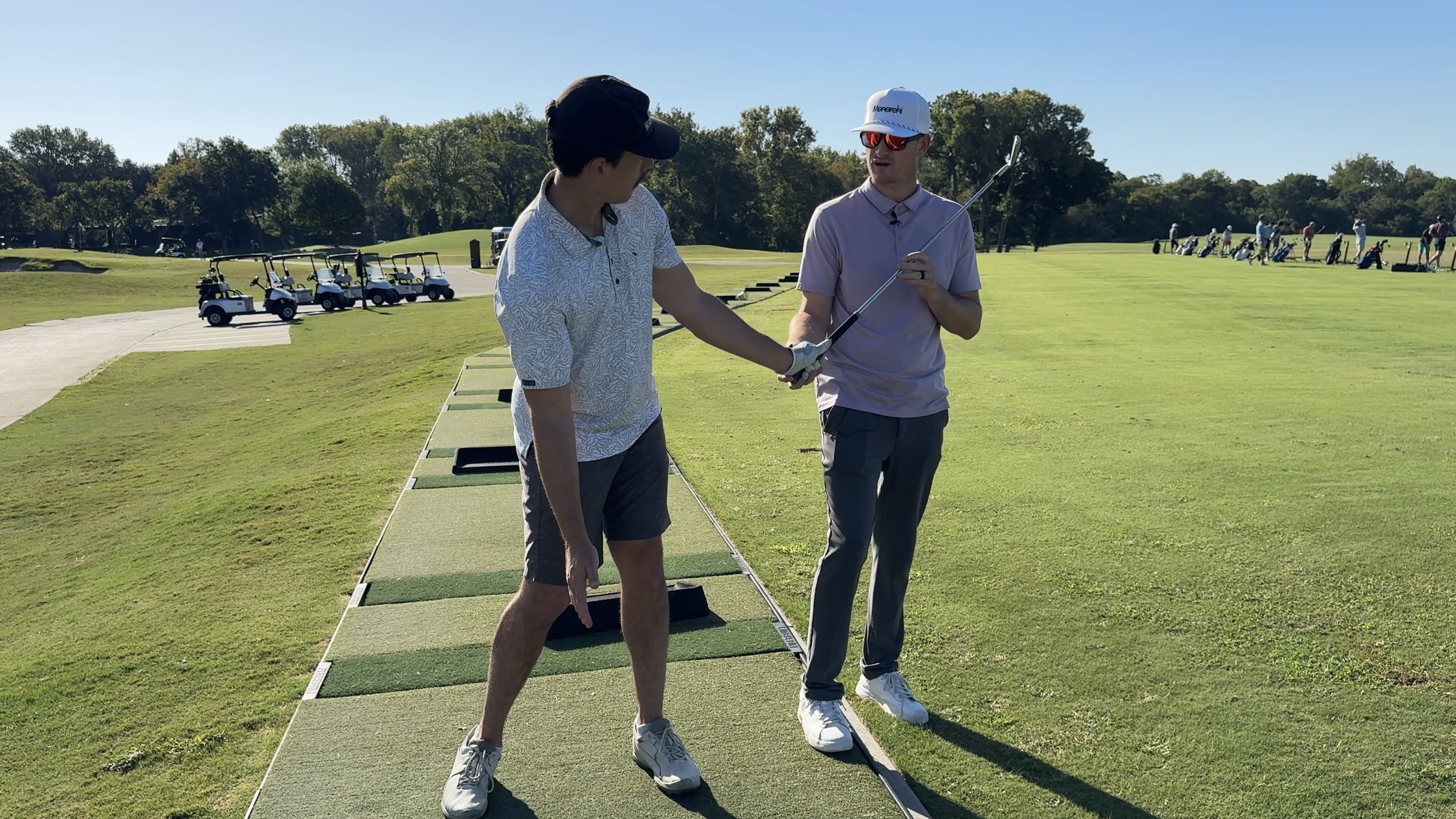Golf coach in Dallas, Casey Harty, teaching a student proper club release on the driving range.